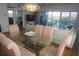 Bright dining room with glass table and pink chairs, overlooking balcony at 6315 Shoreline Dr # 3208, St Petersburg, FL 33708