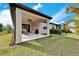 Spacious backyard featuring a covered patio, outdoor furniture, lush lawn, and well-maintained landscaping at 6449 Mooring Line Cir, Apollo Beach, FL 33572
