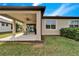 Lush backyard featuring a covered patio with outdoor furniture, manicured lawn, and mature landscaping at 6449 Mooring Line Cir, Apollo Beach, FL 33572