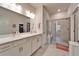 Bright bathroom featuring double sinks, quartz countertop and a large, glass-enclosed shower with bench at 6449 Mooring Line Cir, Apollo Beach, FL 33572