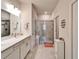 Bright bathroom featuring double sinks, quartz countertop and a large, glass-enclosed shower with bench at 6449 Mooring Line Cir, Apollo Beach, FL 33572
