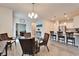 Open-concept dining area featuring wicker chairs, a glass table, and adjacent kitchen bar seating at 6449 Mooring Line Cir, Apollo Beach, FL 33572