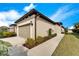 Exterior view of the home showcasing a two-car garage, manicured landscaping, and stucco siding at 6449 Mooring Line Cir, Apollo Beach, FL 33572