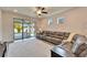 Comfortable living room showcasing a large sectional, sliding glass doors leading to the lanai, and a ceiling fan at 6449 Mooring Line Cir, Apollo Beach, FL 33572