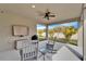 Inviting covered patio with rocking chairs, ceiling fan, and outdoor TV overlooking a landscaped yard at 6449 Mooring Line Cir, Apollo Beach, FL 33572