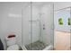 Clean bathroom with a walk-in shower, pebble floor, and glass enclosure at 1061 Sedeeva St, Clearwater, FL 33755