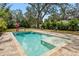 Relaxing rectangular pool with a tanning ledge and surrounding stone pavers at 1061 Sedeeva St, Clearwater, FL 33755