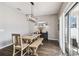 Dining area with wood table, bench seating, modern lighting fixture, and sliding glass doors at 12408 Victarra Pl, New Port Richey, FL 34655