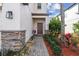 Inviting front entrance with brick accents and landscaping leading to a cozy, covered porch at 12408 Victarra Pl, New Port Richey, FL 34655