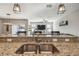 Close up of kitchen sink and breakfast bar open to the living room with sliding glass doors at 12408 Victarra Pl, New Port Richey, FL 34655