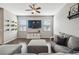 Living room featuring a ceiling fan, a wall-mounted TV, and stylish decor at 12408 Victarra Pl, New Port Richey, FL 34655