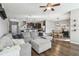 Open concept living room with ceiling fan, gray sectional sofa, and views to the kitchen and dining room at 12408 Victarra Pl, New Port Richey, FL 34655