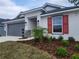 Newly built home with gray siding, red shutters, and a palm tree at 13154 Kent Bradley St, Dade City, FL 33525