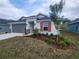 New construction home with gray siding, red shutters, and landscaping at 13154 Kent Bradley St, Dade City, FL 33525