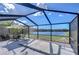 Screened-in patio features a spa, dining set, and a scenic view of the lake offering a serene outdoor space at 13908 Orange Dale Pl, Tampa, FL 33625