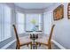 Cozy breakfast nook with a round table, chairs, and bright natural light streaming through the bay windows at 13908 Orange Dale Pl, Tampa, FL 33625