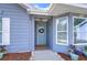 Charming home featuring a light blue front door adorned with a wreath and accented by colorful flower pots at 13908 Orange Dale Pl, Tampa, FL 33625