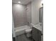 Updated bathroom with gray tile and vanity at 1404 W Granfield Ave, Plant City, FL 33563