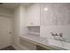 Laundry room with white cabinets, gray countertop, and subway tile backsplash at 1404 W Granfield Ave, Plant City, FL 33563