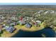 Aerial view of a home with a screened-in pool in a neighborhood with mature trees and a pond at 15110 Shearcrest Dr, Lithia, FL 33547