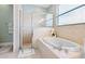 Bright bathroom showcasing a glass shower, soaking tub, and a serene view at 15110 Shearcrest Dr, Lithia, FL 33547