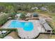 Aerial view of a large community pool with ample seating, a splashpad, and landscaped surroundings at 15110 Shearcrest Dr, Lithia, FL 33547