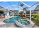 Backyard screened pool with a spa, tropical landscaping, a summer kitchen and ample space for entertainment at 15110 Shearcrest Dr, Lithia, FL 33547