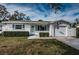 Charming single-story home featuring manicured bushes, an American flag, and a garage at 1570 S Michigan Ave, Clearwater, FL 33756