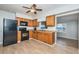 The kitchen features wood cabinetry, black appliances, vinyl flooring, and an eat-in area at 1570 S Michigan Ave, Clearwater, FL 33756