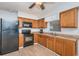 Kitchen features wood cabinetry, laminate countertops, stainless steel sink, and black appliances at 1570 S Michigan Ave, Clearwater, FL 33756