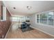 Bright living room with wood floors, brick accent wall, and large windows at 1570 S Michigan Ave, Clearwater, FL 33756