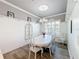 Elegant dining room features a white table, chandelier, and white wainscoting at 15856 Cobble Mill Dr, Wimauma, FL 33598