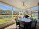 Screened patio with lake view, outdoor dining set, and ceiling fan at 15856 Cobble Mill Dr, Wimauma, FL 33598