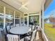 Screened patio overlooking a lake, with seating for dining and a ceiling fan at 15856 Cobble Mill Dr, Wimauma, FL 33598