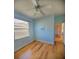 Light blue bedroom with hardwood floors and ceiling fan at 16103 Muirfield Dr, Odessa, FL 33556