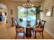 Elegant dining room features stylish chandelier, glass table, and views of the inviting outdoor pool at 16103 Muirfield Dr, Odessa, FL 33556