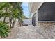 Outdoor patio with fire pit, stone wall, and tropical plants at 16317 Gulf Blvd, Redington Beach, FL 33708