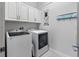 Convenient laundry room with washer, dryer, and upper cabinets at 16317 Gulf Blvd, Redington Beach, FL 33708