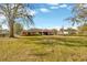 Large grassy backyard with mature trees and a partially visible house at 1702 S Miller Rd, Valrico, FL 33594