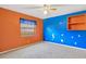 Bedroom with orange and blue walls, ceiling fan at 1702 S Miller Rd, Valrico, FL 33594