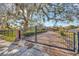 Ornate black metal gate opens to a brick driveway, leading to the house at 1702 S Miller Rd, Valrico, FL 33594