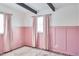 Bedroom with pink walls, wood floors and window curtains at 1707 Darlington Dr, Tampa, FL 33619