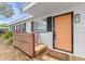 Inviting front porch with wood accents, a chair for relaxing, and a freshly painted orange front door at 1707 Darlington Dr, Tampa, FL 33619