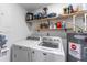 Practical laundry room with modern washer and dryer units, utility shelving, and water heater at 1707 Darlington Dr, Tampa, FL 33619