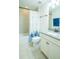 Bathroom featuring granite countertops, framed mirror, shower with tile surround, and blue accents at 1708 Sunset Wind Loop, Oldsmar, FL 34677