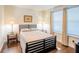 Bedroom featuring a queen-sized bed, wood floors, bedside tables, and natural light at 1708 Sunset Wind Loop, Oldsmar, FL 34677