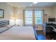 Cozy bedroom features a work desk, ceiling fan, and a sunny window view at 1708 Sunset Wind Loop, Oldsmar, FL 34677