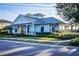 Inviting Bayside Terrace clubhouse with light blue exterior and a metal roof, surrounded by lush landscaping and a well-manicured lawn at 1708 Sunset Wind Loop, Oldsmar, FL 34677