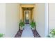 Front entryway featuring a doorway and symmetrical potted plants, creating a welcoming entrance at 1708 Sunset Wind Loop, Oldsmar, FL 34677