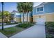 Attractive townhome featuring a blue and yellow exterior, with a well-maintained lawn and palm trees at 1708 Sunset Wind Loop, Oldsmar, FL 34677